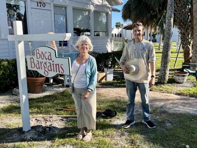 woman and young man stand next to the Boca Bargains sign